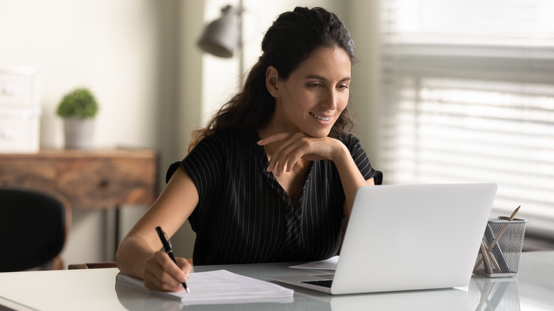 Woman taking notes from laptop