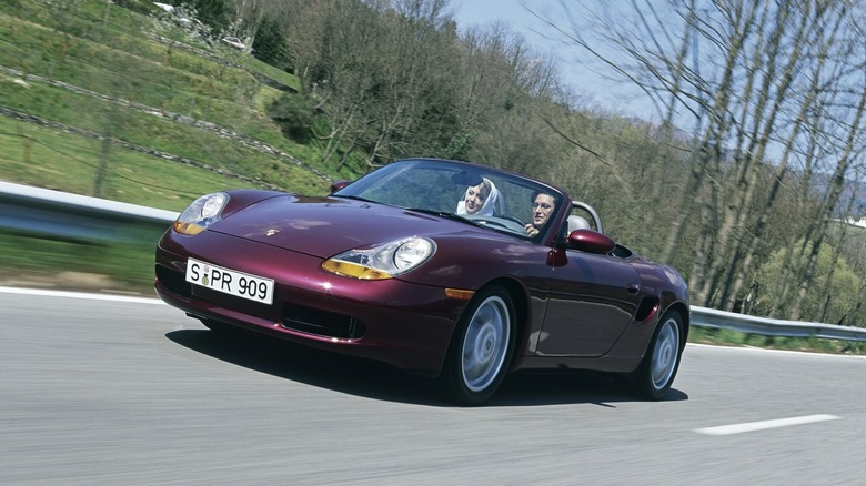 Burgundy 1996 Porsche Boxster roadster seen from left front on a country road