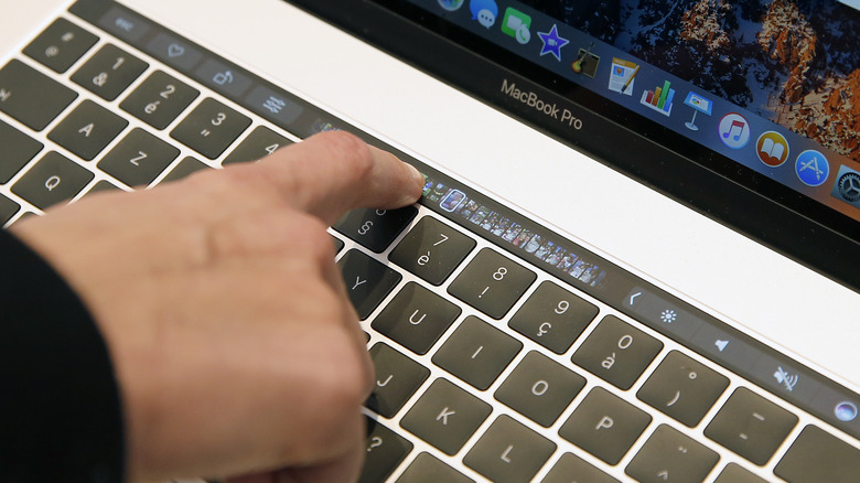 Person operating the Touch Bar on MacBook Pro (late-2016)