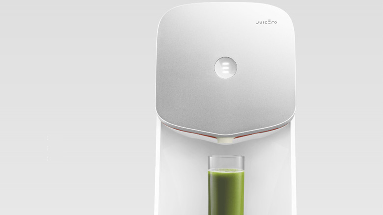 Juicero machine with a glass of green juice
