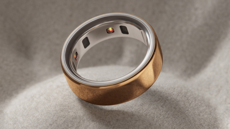 Gold Oura ring on a grey fabric background