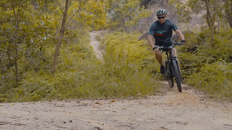 A mountain biker riding the Ancheer Gadiator on a dirt trail