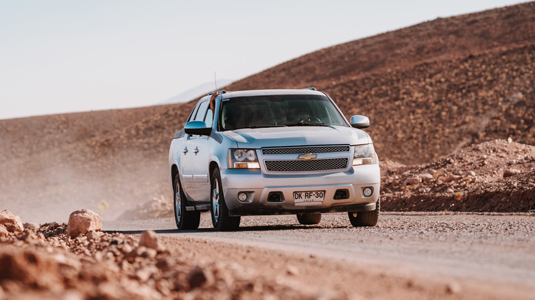 A GM-made Chevrolet Avalanche pickup truck on a dusty road in South America.