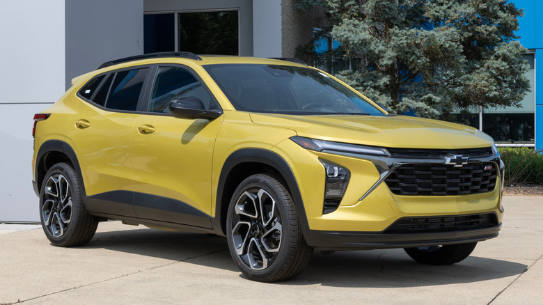 A yellow Chevrolet Trax in front of a building.