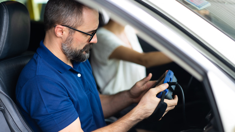 person checking OBD scanner