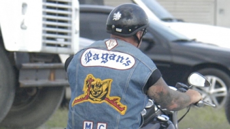 Pagan's member drives away on motorcycle wearing "colors"