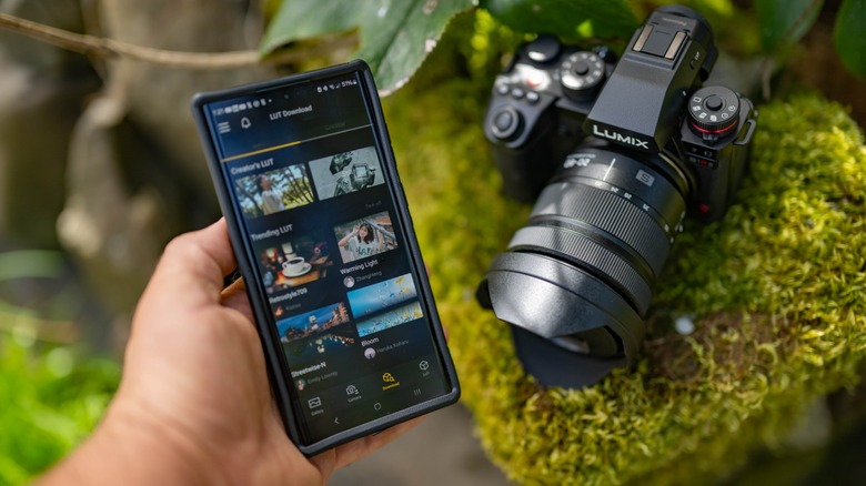 Panasonic Lumix S1RII on a mossy ledge next to a smartphone with the LUMIX Lab app running.