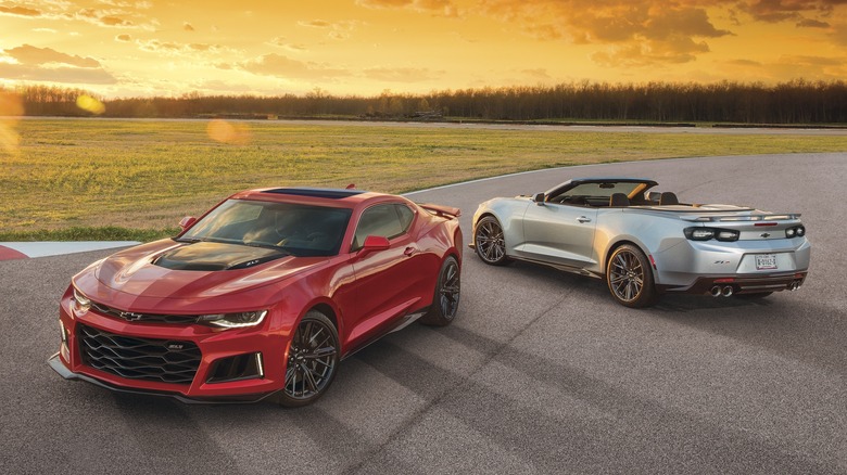 Red and silver Chevrolet Camaro ZL1s parked on a race track