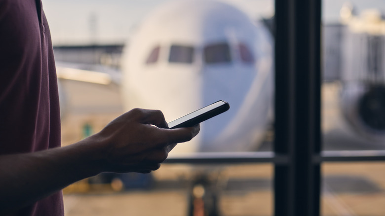 Traveler uses phone at the airport