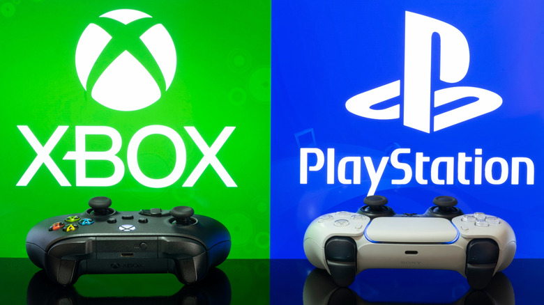 Xbox and PlayStation controllers side-by-side on a table with console logos behind them