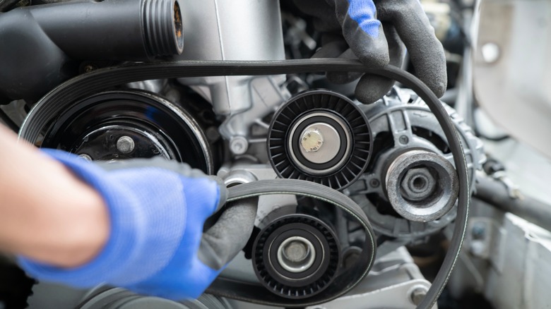 Mechanic working on vehicle's drive belt