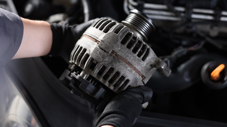 Mechanic holding alternator