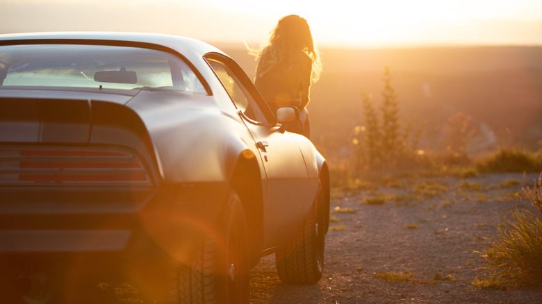 Woman sitting on Firebird in sunset 