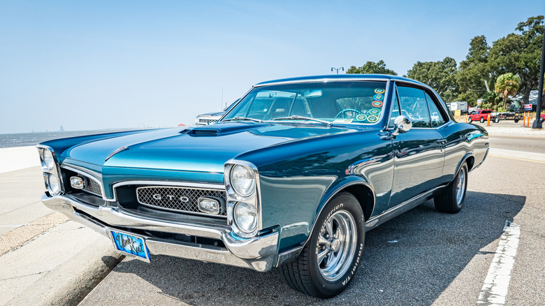 front left view of blue Pontiac GTO coupe parked in beachfront lot