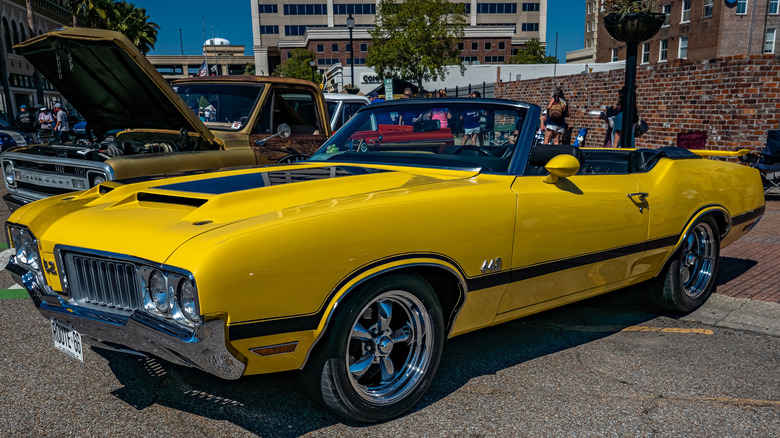 Yellow 1970 Oldsmobile 442 convertible at downtown car show