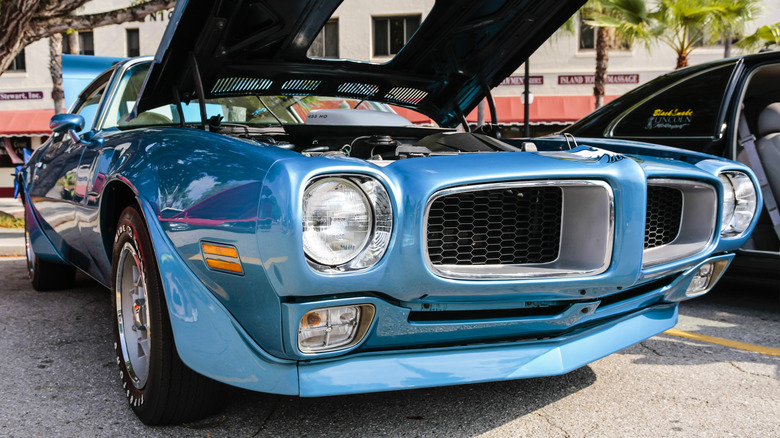 A blue Firebird Trans Am with the hood popped