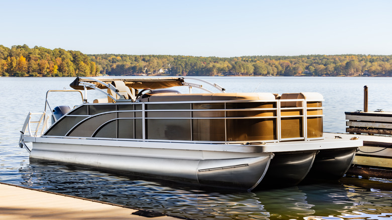 A pontoon boat on a marina dock.