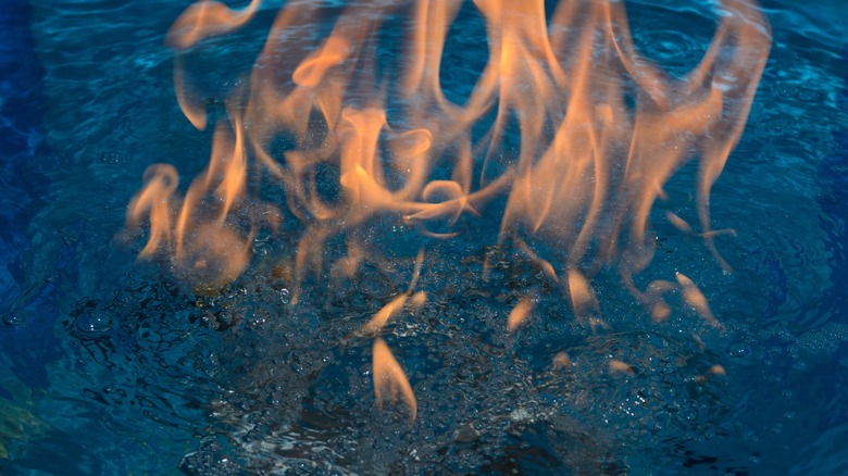 Fire burns above the water
