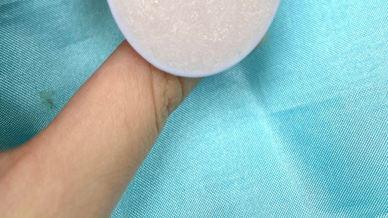 A crystal-finished PopSocket in front of a blue background.