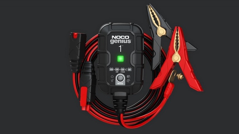 Noco Genius 1 battery charger with cables against a black background.
