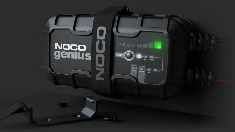 The Noco Genius 10 battery charge with a strap around it and bracket below it.