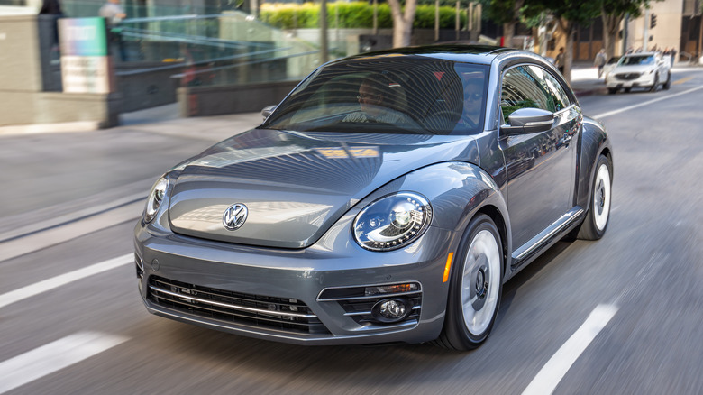 Blue VW Beetle driving on city street