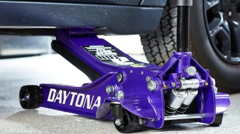 Using Harbor Freight's Daytona-brand floor jack to lift a car.