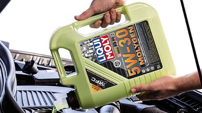 Person pouring motor oil into an engine