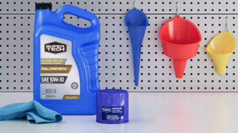 Bottle of motor oil next to filter and rag with funnels
