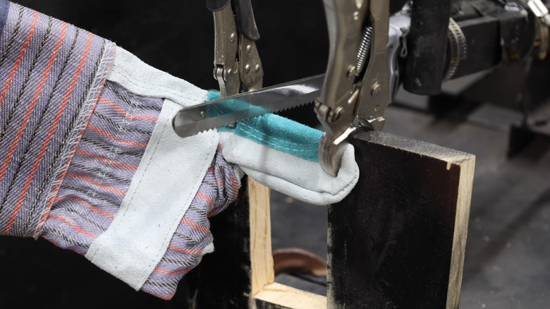 A lavender colored glove is tested on a cutting rig