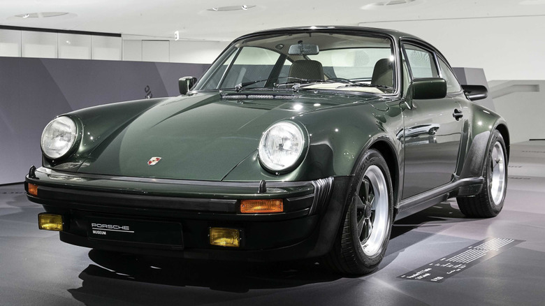 Forest green Porsche 911 Turbo in a light-colored museum display.