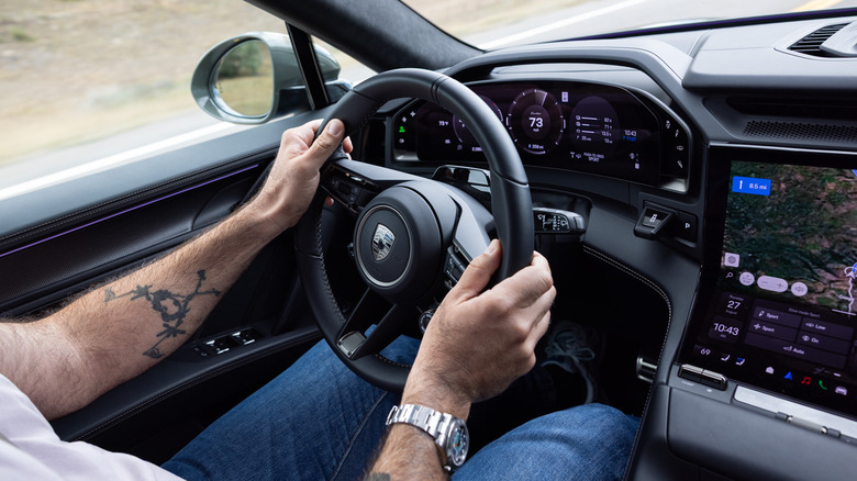2026 Porsche Cayenne Electric Turbo driver hands on the steering wheel