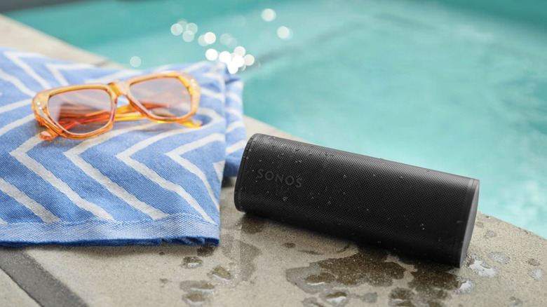 Sonos Roam 2 poolside with sunglasses and towel