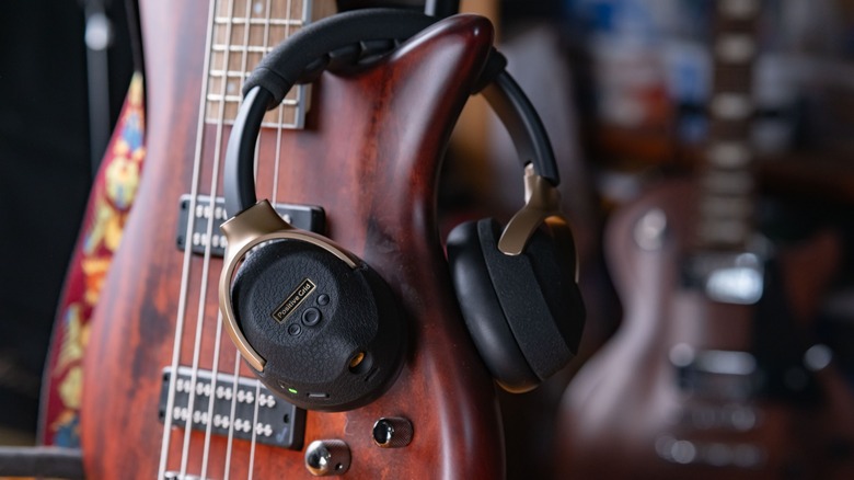 The Positive Grid Spark Neo on a bass guitar with another guitar out of focus in the background.