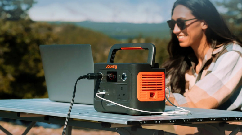 Woman using laptop connected to Jackery power station