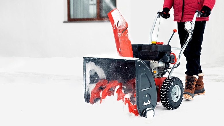 motorized snowblower getting pushed through the snow
