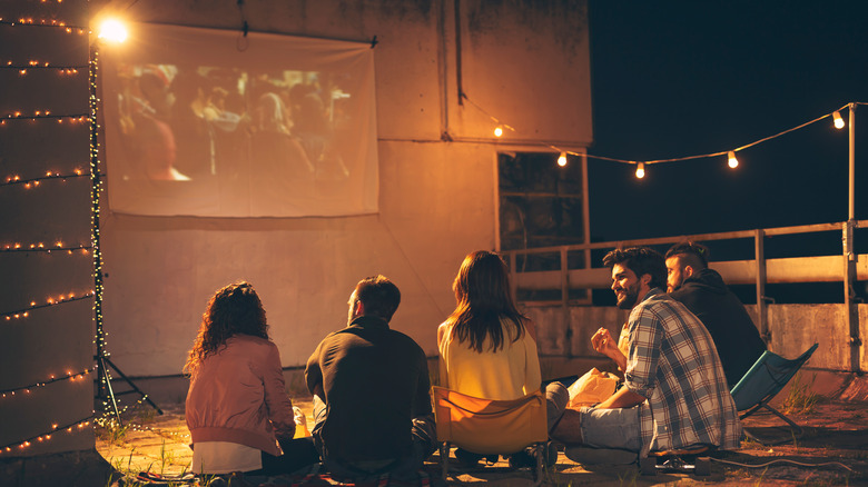 Group enjoying projected movie outside