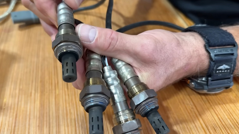 A person comparing oxygen sensors