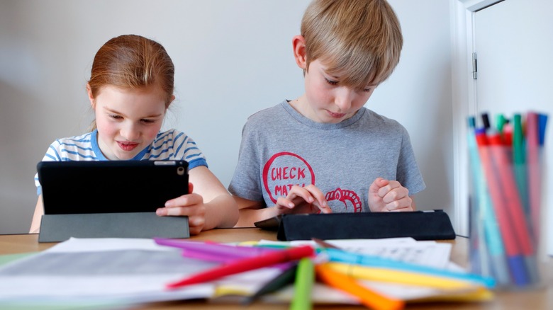 Two kids using ipads