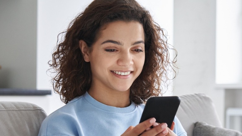 Amused woman looking at phone