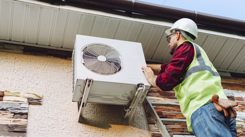 A technician working on an outdoor unit of an air conditioner