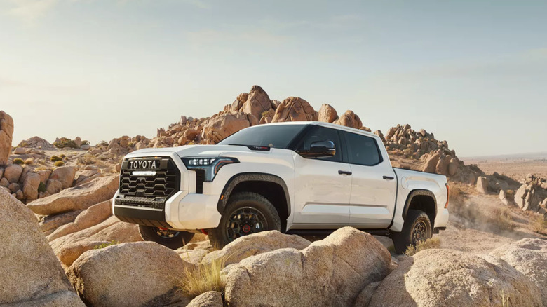 A white 2026 Toyota Tundra off-roading on rocks