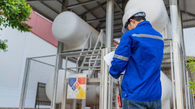Man supervising tanks holding helium being used for clean energy