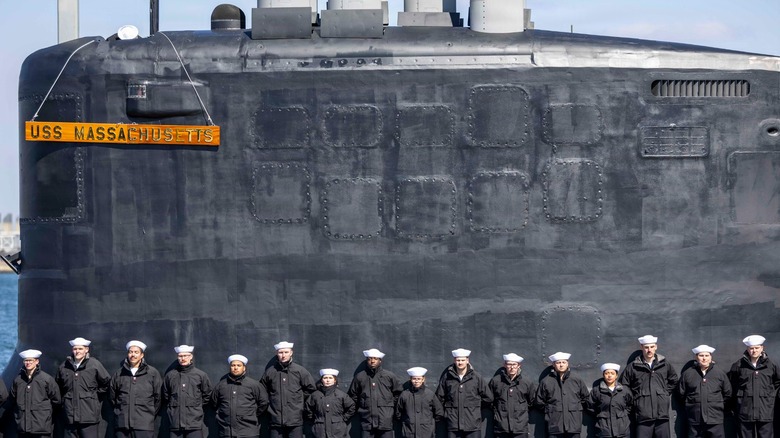 Sailors assigned to the USS Massachusetts standing before the boat during its commissioning