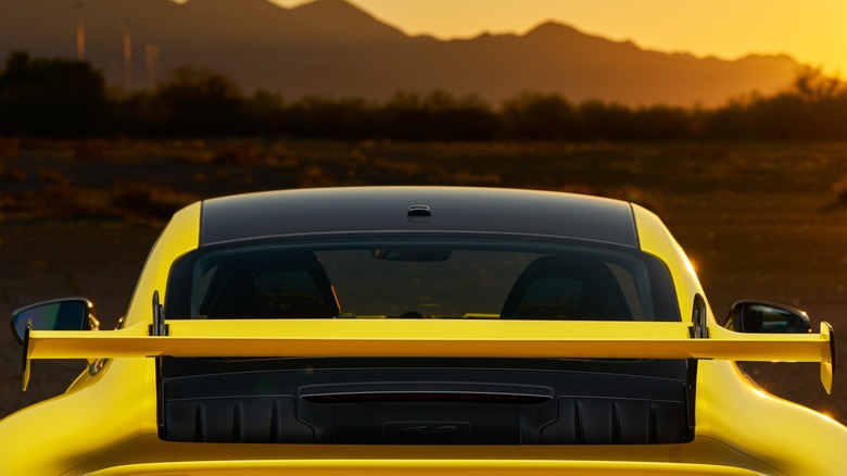 The rear wing of a yellow Porsche