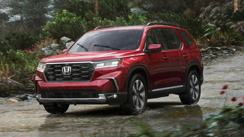 2025 Honda Pilot driving through a rainy forest