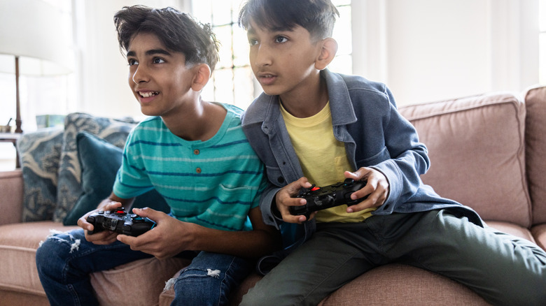 Kids on the couch holding wireless game controllers