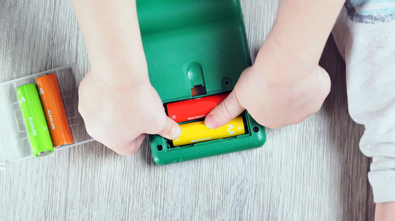 Child putting batteries in a toy