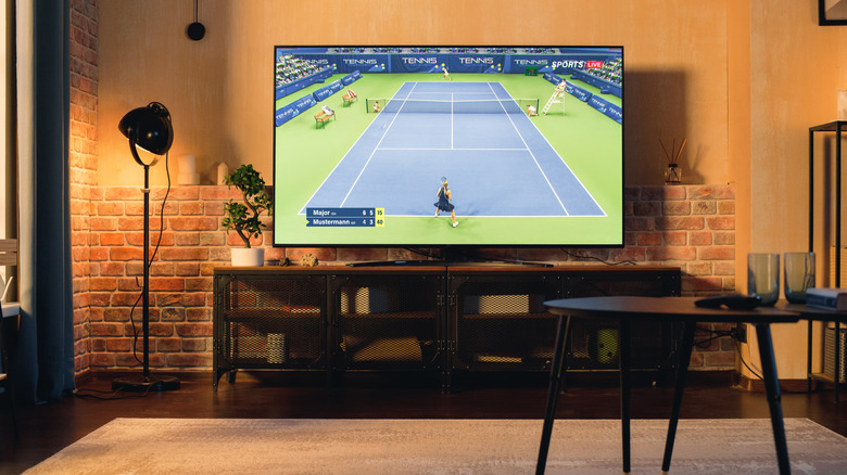 Tennis game being played on a TV in a loft