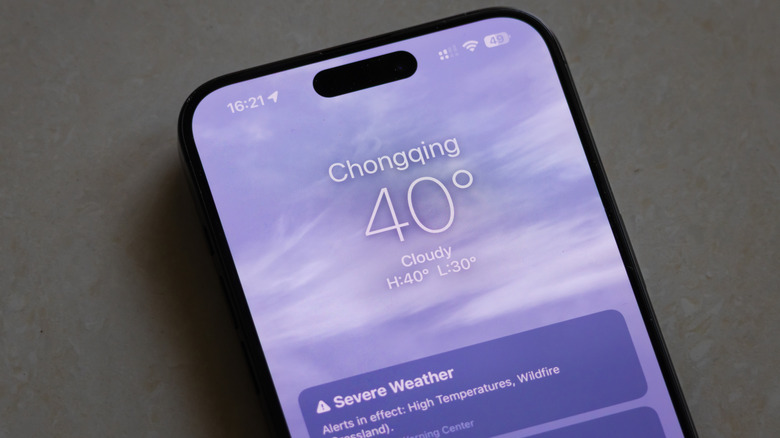 A smartphone placed on the floor displays a weather app showing a temperature of 40°C